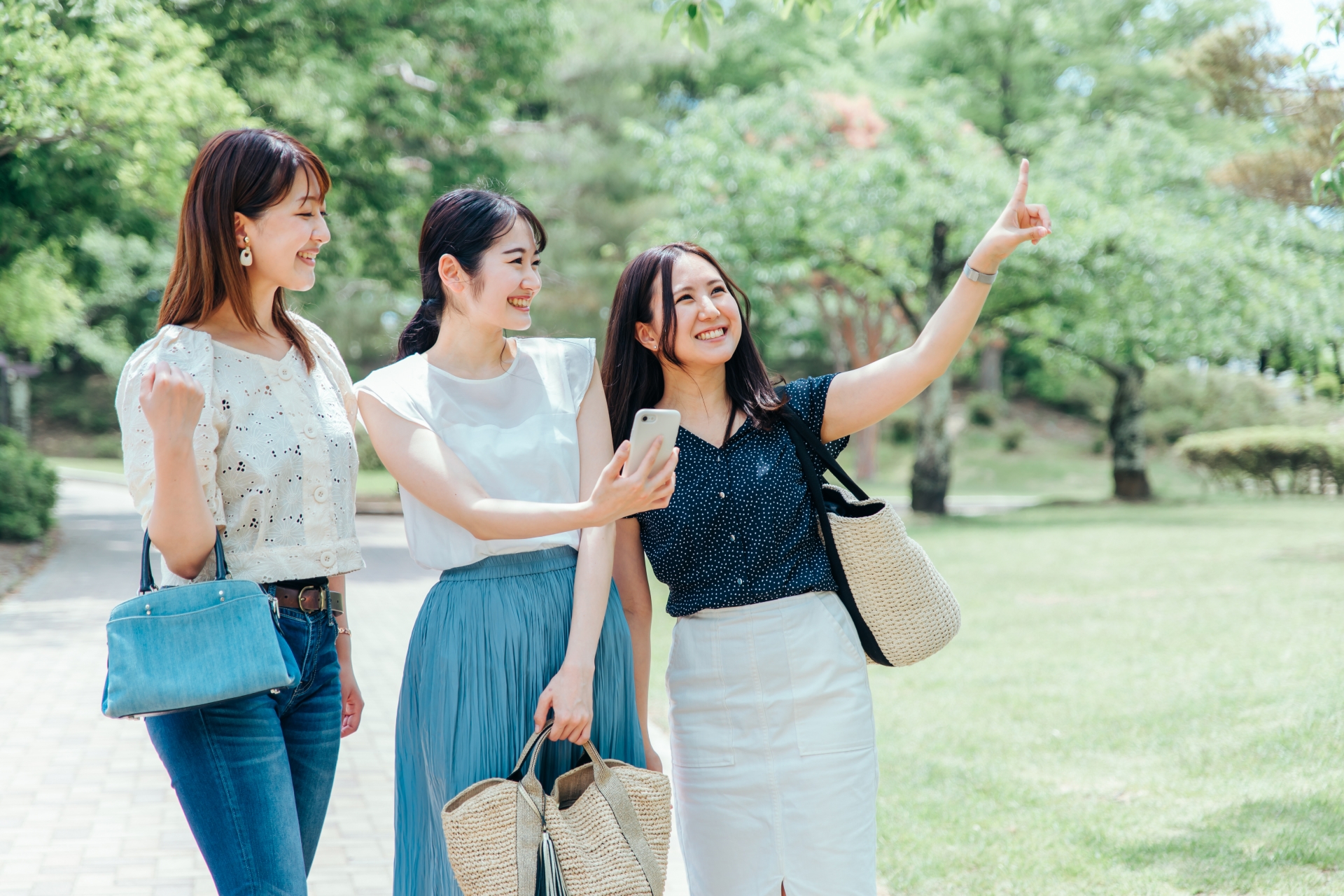 三名女性旅伴在戶外一起查看手機與討論方向