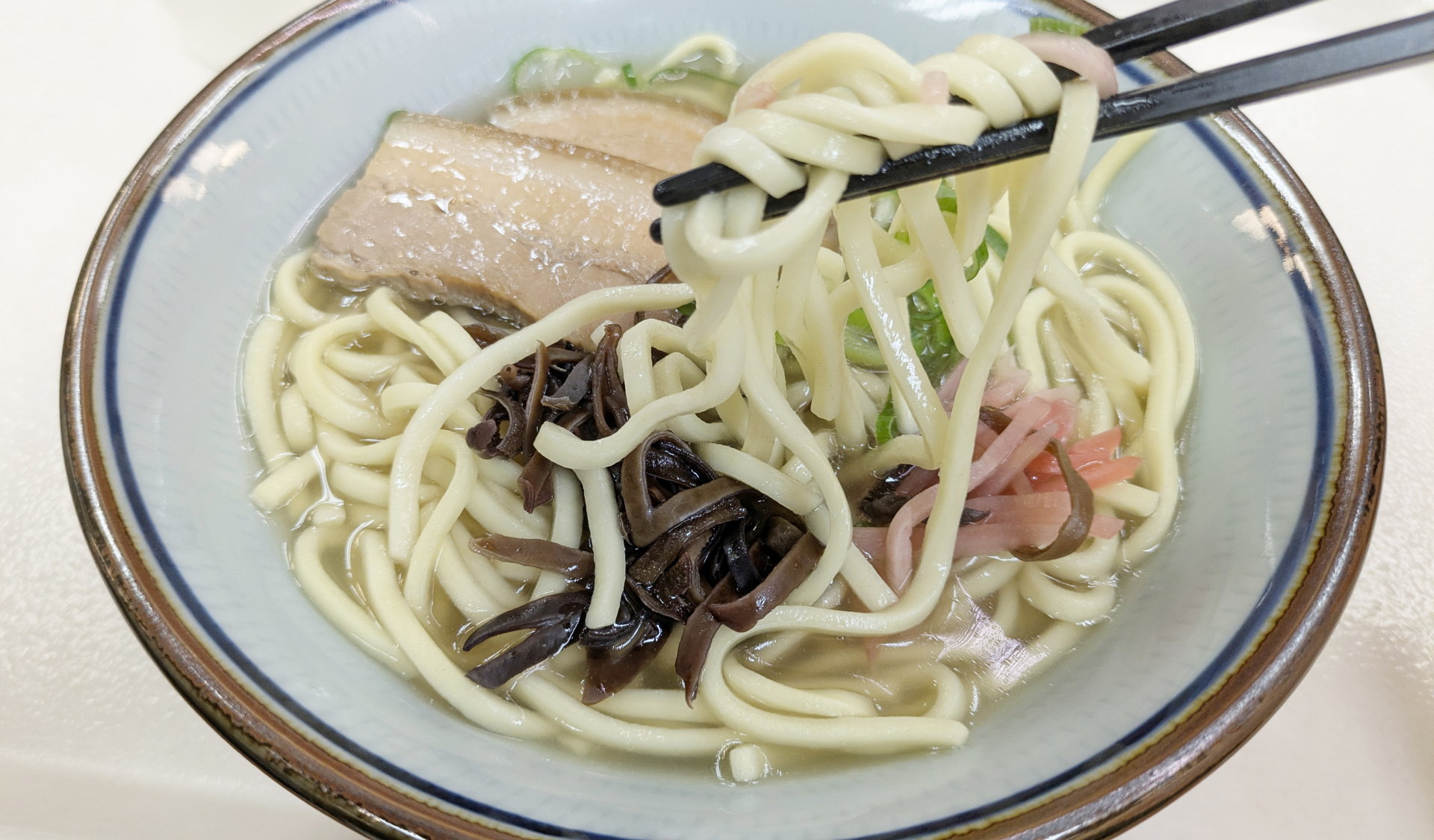 筷子夾起麵條的沖繩麵與豬肉配料